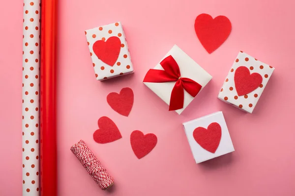 Валентинки подарочные коробки, красный лук и войлочные сердца — стоковое фото