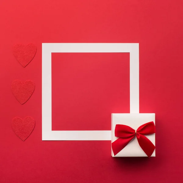Caixa de presente embrulhado artesanal e corações vermelhos — Fotografia de Stock
