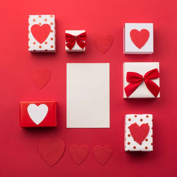 Cajas de regalo envueltas a mano, corazones rojos y tarjeta de papel vacía — Foto de Stock