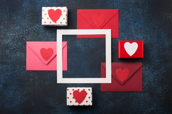 Červené obálky, dárky a červená srdce na klasickém modrém pozadí. — Stock fotografie