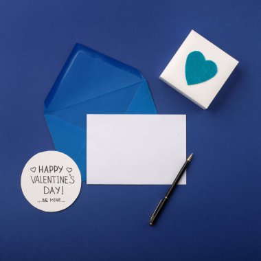 Mavi zarf, hediyeler ve mavi üzerine beyaz kalpler. 