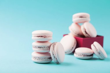 Hediye kutusunda Roze kurabiyeleri. Mavi arkaplanda fotokopi alanı olan tatlı pembe badem kurabiyeleri. Seçici odaklanma. Tatil zamanı kavramı