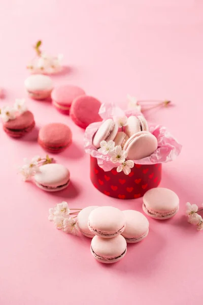 Roze Macarons Rode Geschenkdoos Kersenbloesems Zoete Macarons Aanwezig Roze Achtergrond — Stockfoto