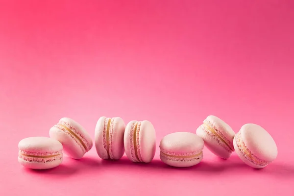 フランスのクッキーマカロンをバラ コピースペース付きピンクの背景に甘いマカロン ラズベリー ストロベリー チェリーまたはブルーベリーの味 最上階だ 休日のコンセプト — ストック写真