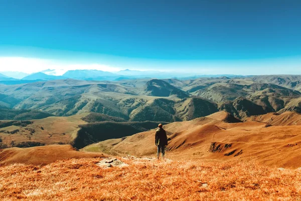 Bir adam vadi boyunca yürür. Kafkas sırtı. Dağ manzarası. güneşli bir gün