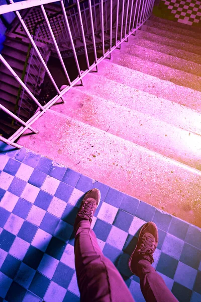 階段の下の近くのスニーカーで脚のサイケデリックなピンクの紫色の写真 先に行くのが怖い 長い道のりだ — ストック写真