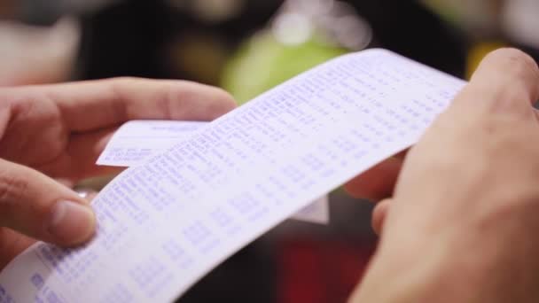 Een Man Controleert Een Cheque Van Aankopen Een Supermarkt Uitgavenberekeningen — Stockvideo