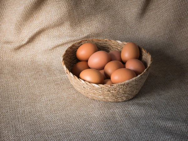 蛋在篮子在褐色袋子布料 — 图库照片