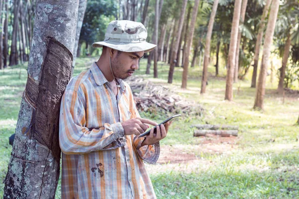 Νέος κηπουρός άνθρωπος που κρατά την ψηφιακή δισκίο στον κήπο — Φωτογραφία Αρχείου