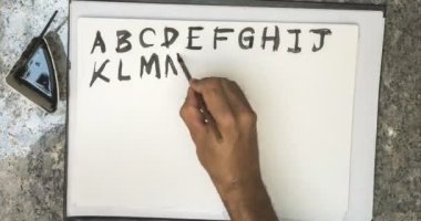 Alfabe ve sayı siyah mürekkep ile beyaz kağıt üzerine yazma Timelapse 