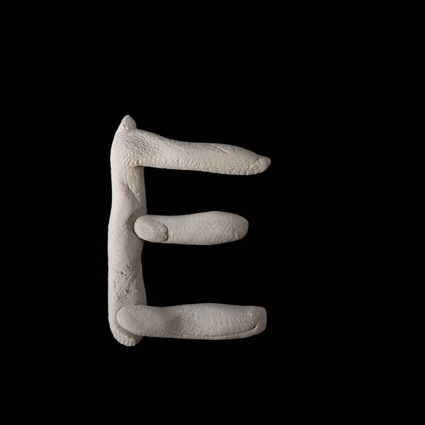 Алфавит Е по глине на коричневом дереве — стоковое фото