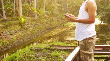 Gündelik elbise sabah Teras Bahçe yakınındaki smartphone kullanarak Asya adam