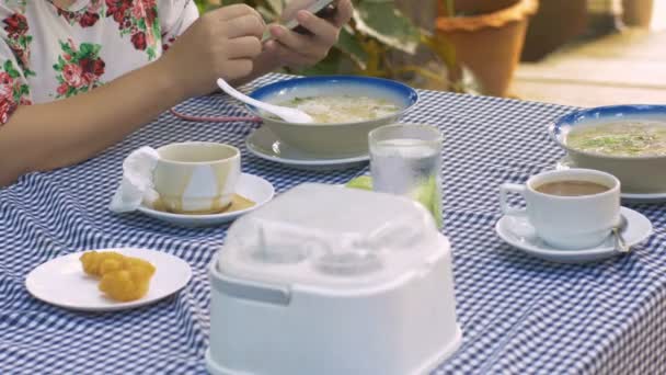 Frau spielt beim Frühstück Smartphone — Stockvideo
