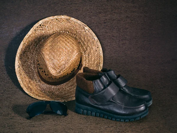 Leather shoes, sunglasses and weaving hat on brown background — Stock Photo, Image