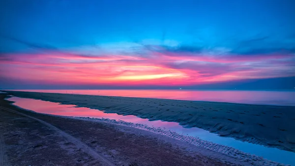 Východ slunce na ranní obloze nad mořem se židlí a slunečníkem na pláži — Stock fotografie