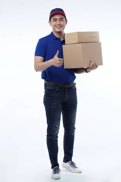 Jovem entrega em uniforme azul com pacotes — Fotografia de Stock