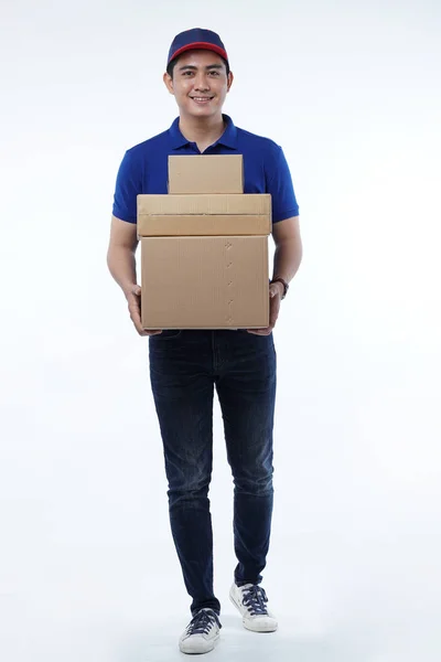 Entrega de hombre joven en uniforme azul con paquetes — Foto de Stock