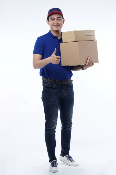 Jeune homme livraison en uniforme bleu avec paquets — Photo