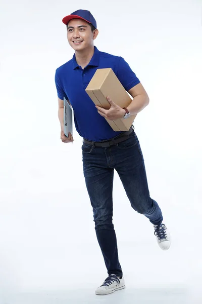 Entrega de hombre joven en uniforme azul con paquetes — Foto de Stock