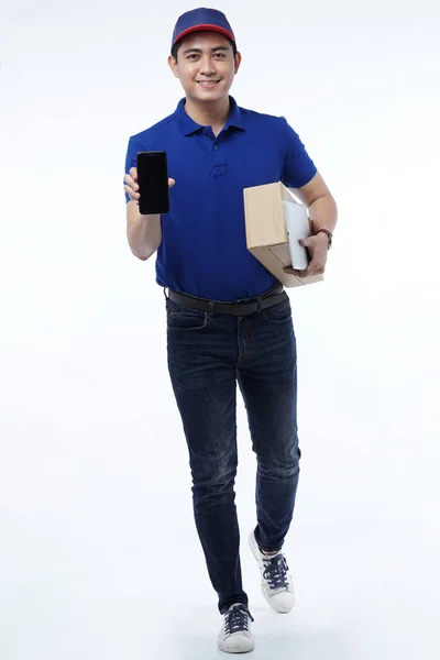 Jovem entrega em uniforme azul com pacotes — Fotografia de Stock