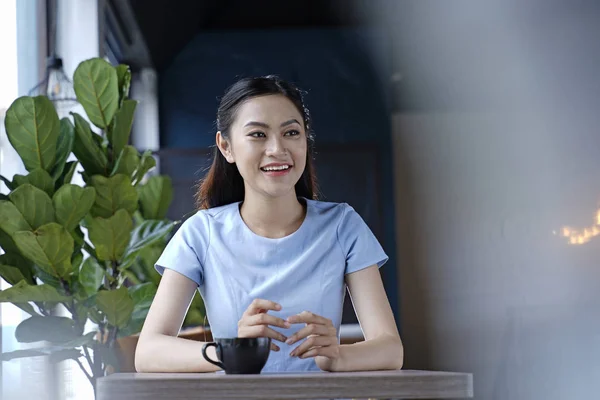 Porträt einer jungen Asiatin, die im Café beschäftigt ist — Stockfoto