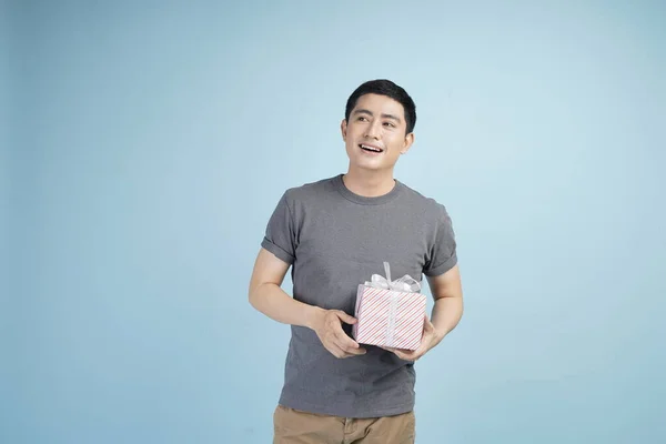 Young asian man with credit card doing online transaction buy, purchase or sell stuff, in studio isolated gray background