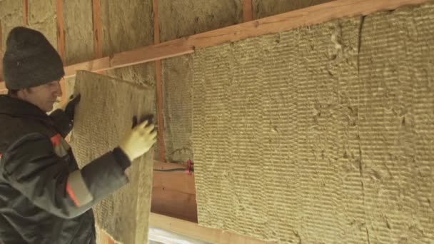 Man laying insulation in a wall — Stock Video