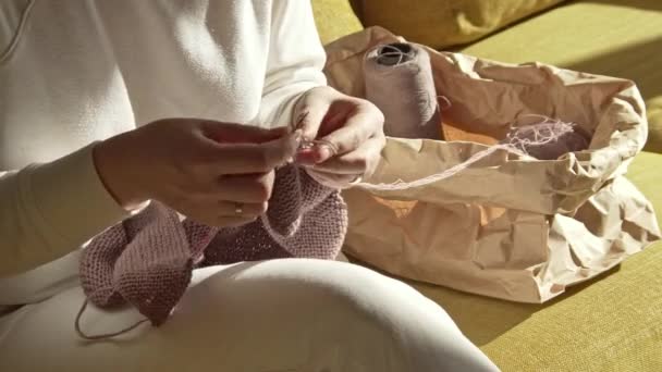 Woman knitting thread from the package on a sunny day — Stock Video