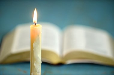 Mum ile arka planda açık İncil