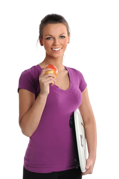 Молодая женщина с яблоком и чешуей — стоковое фото