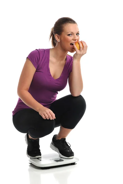 Kobieta na skali gryzienie Apple — Zdjęcie stockowe
