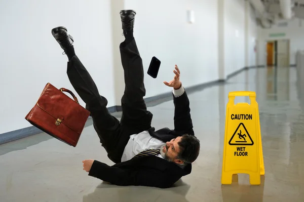 Empresario cayendo om piso mojado — Foto de Stock