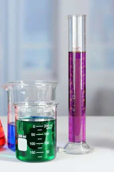 Zlewki laboratoryjne i stopniowany Cylinder na stole — Zdjęcie stockowe