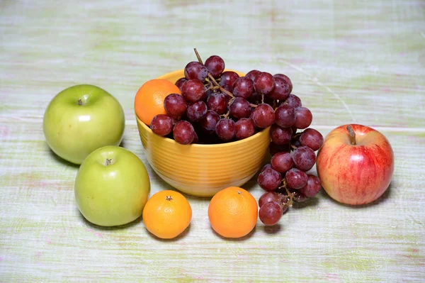 Gyümölcsök és a tálat, fából készült asztal — Stock Fotó