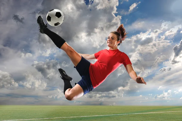 Ženský fotbalový hráč kope míč — Stock fotografie