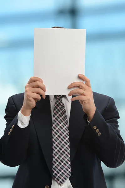 Empresário escondido atrás do papel — Fotografia de Stock