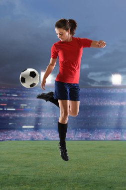 Stadyumda top oynayan bayan futbolcu