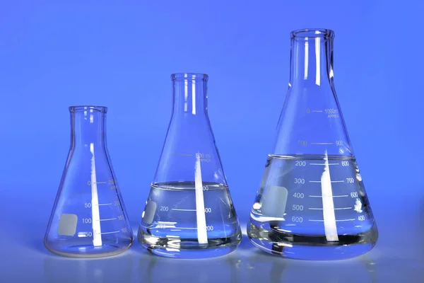 Laboratory Flasks Over Blue Background — Stock Photo, Image