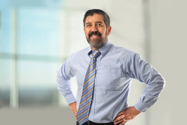 オフィス内の腰に手を持つヒスパニック系ビジネスマンの肖像画 — ストック写真