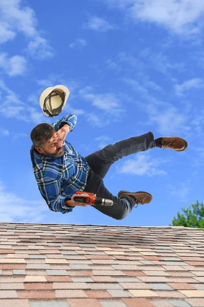 屋根の上でバランスを失うシニア男 ストック画像