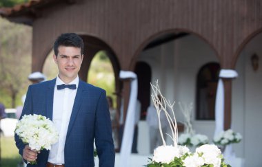 Genç yakışıklı damat gelecekteki eşi deniz yanında church yakınındaki bekliyor.