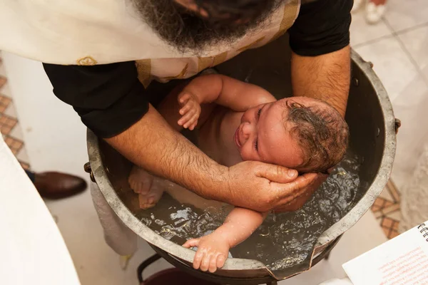 刚出生的婴儿水洗礼仪式。在希腊基督教东正教洗礼. — 图库照片