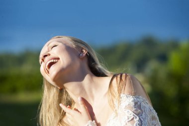 Güzel beyaz gelinlik giyen deniz kıyısında yürüyüş güzel gelin portresi