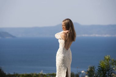 Güzel beyaz gelinlik giyen deniz kıyısında yürüyüş güzel gelin portresi