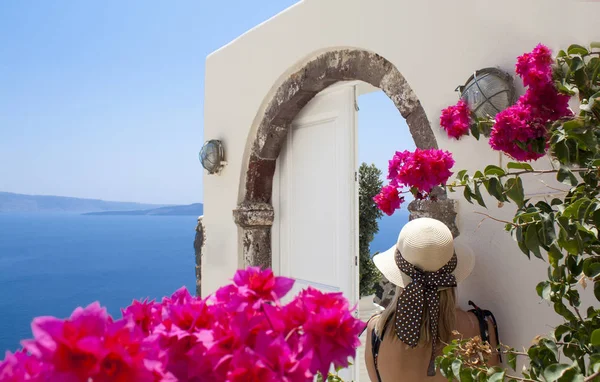 Vacker kvinna promenader och njuta av fantastisk utsikt över ön Santorini. — Stockfoto