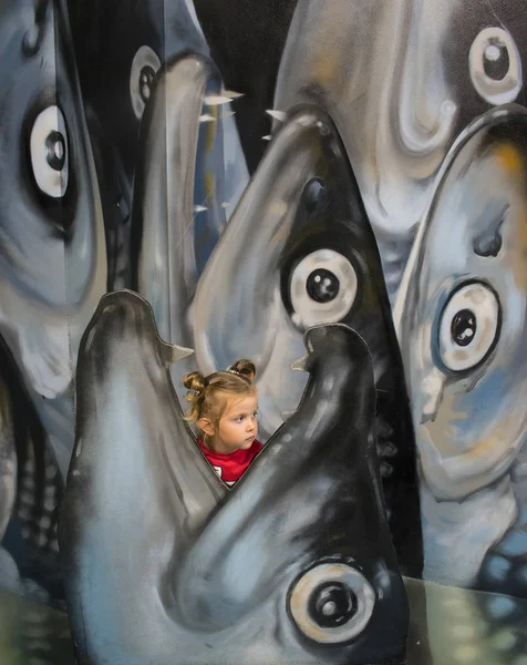 Little girl in open fish mouth. playground — Stock Photo, Image