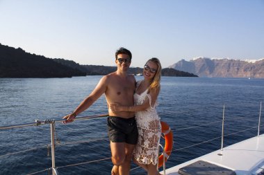 Yatta gün batımında romantik çift. Santorini'de tekne turu