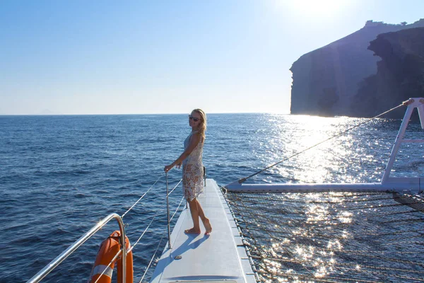 Frau, die bei Sonnenuntergang mit dem Boot zwischen den Inseln unterwegs ist. sommer sntorini, griechenland — Stockfoto
