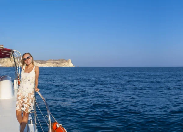 Frau, die bei Sonnenuntergang mit dem Boot zwischen den Inseln unterwegs ist. sommer sntorini, griechenland — Stockfoto