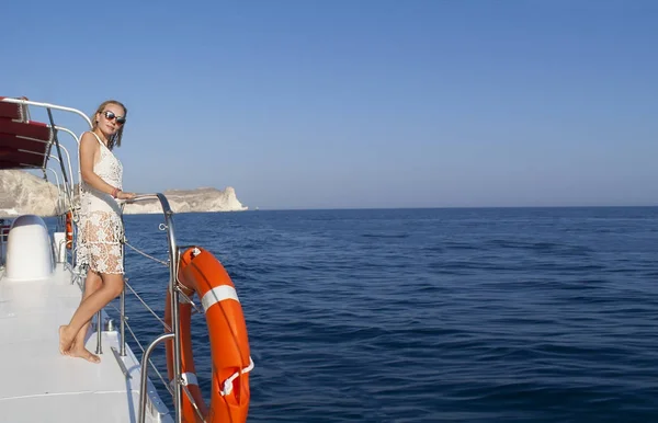 Frau, die bei Sonnenuntergang mit dem Boot zwischen den Inseln unterwegs ist. sommer sntorini, griechenland — Stockfoto